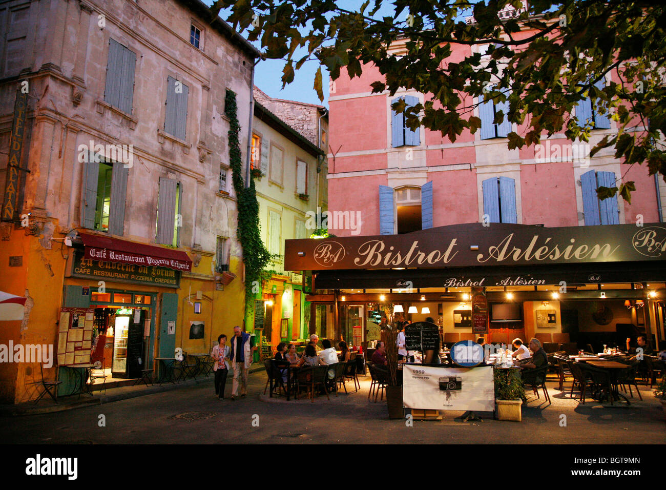 Les gens assis à un café à la place du Forum, Arles, Provence, France. Banque D'Images