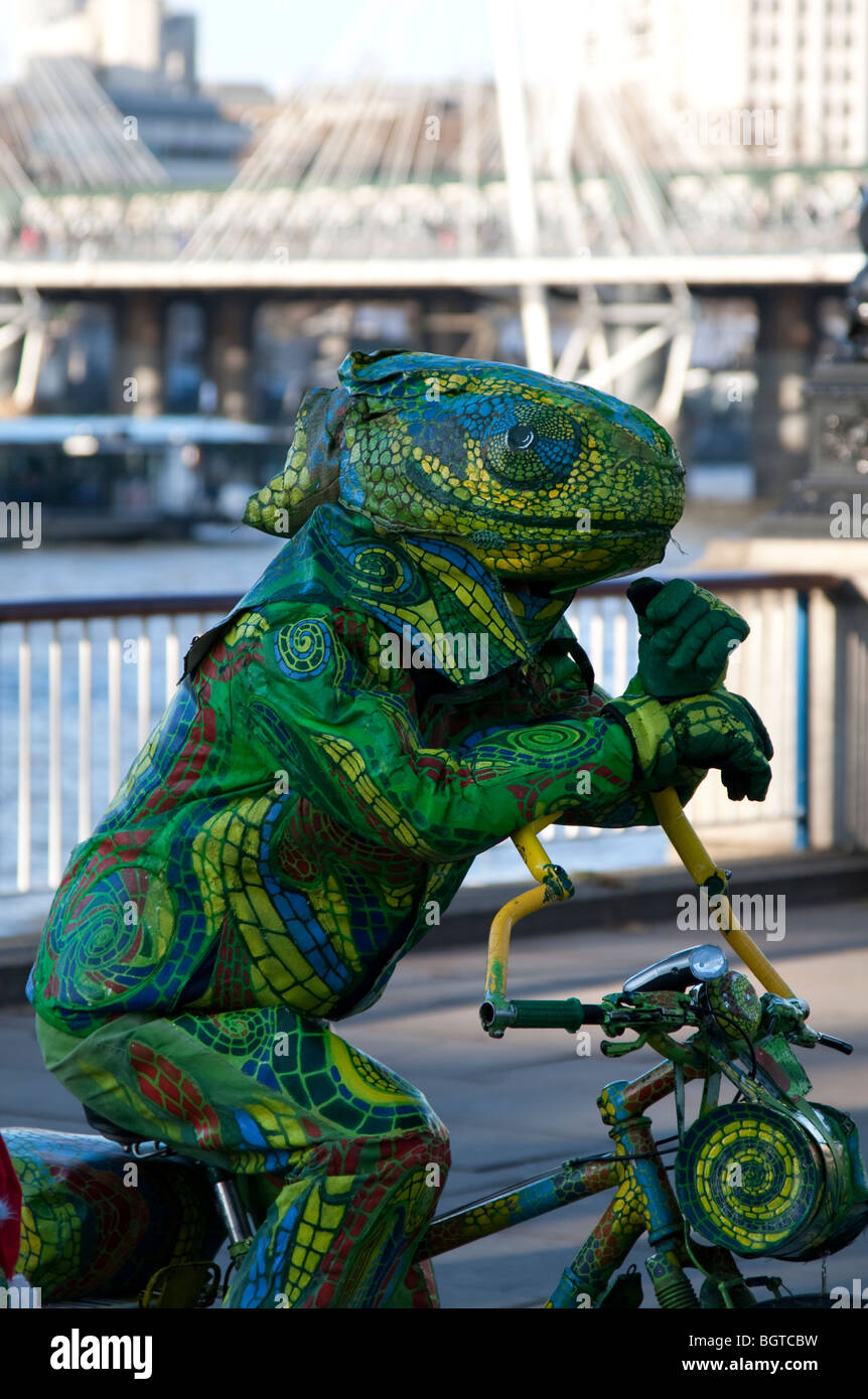 Musicien ambulant déguisé en un lézard sur la rive sud de la Tamise, Londres Banque D'Images