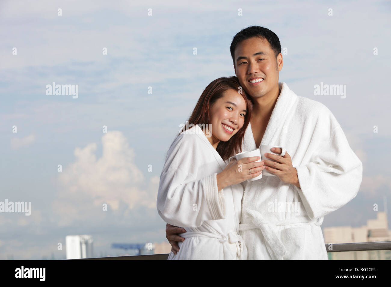 Jeune couple dans des robes hugging and smiling Banque D'Images
