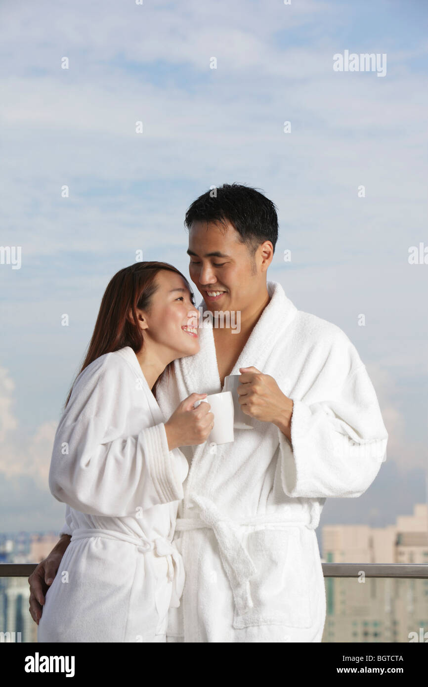 Jeune couple dans des robes smiling at each other Banque D'Images