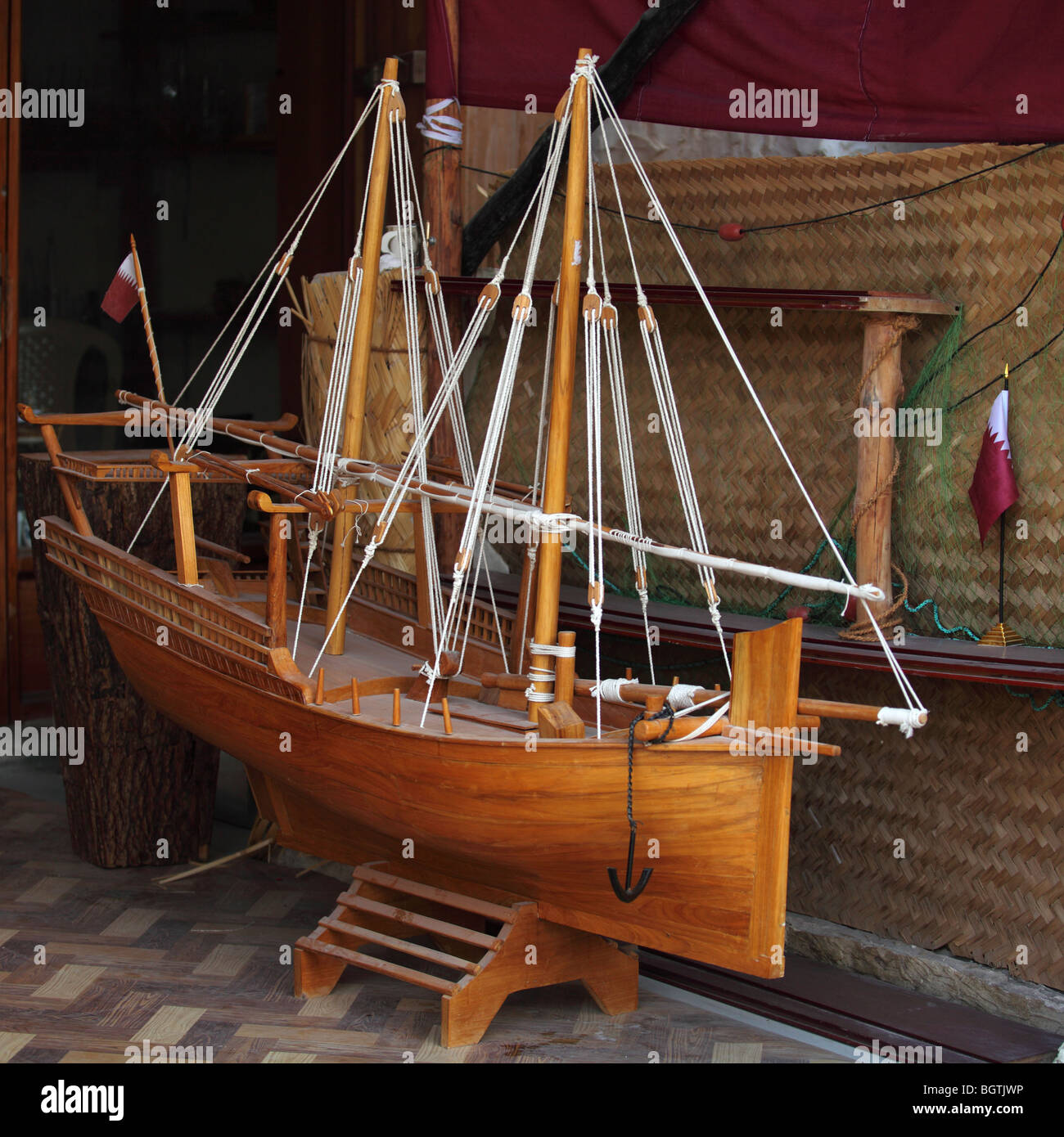 Un grand modèle d'un dhow avec le drapeau du Qatar, sur la vente au Souq Waqif, Doha, Qatar. Banque D'Images