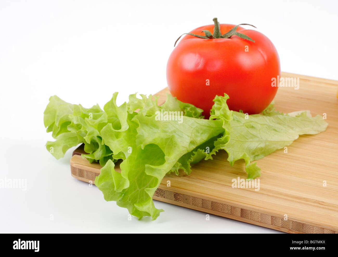Salade de tomates et de feuille sur une planche en bois, isolés studio Banque D'Images