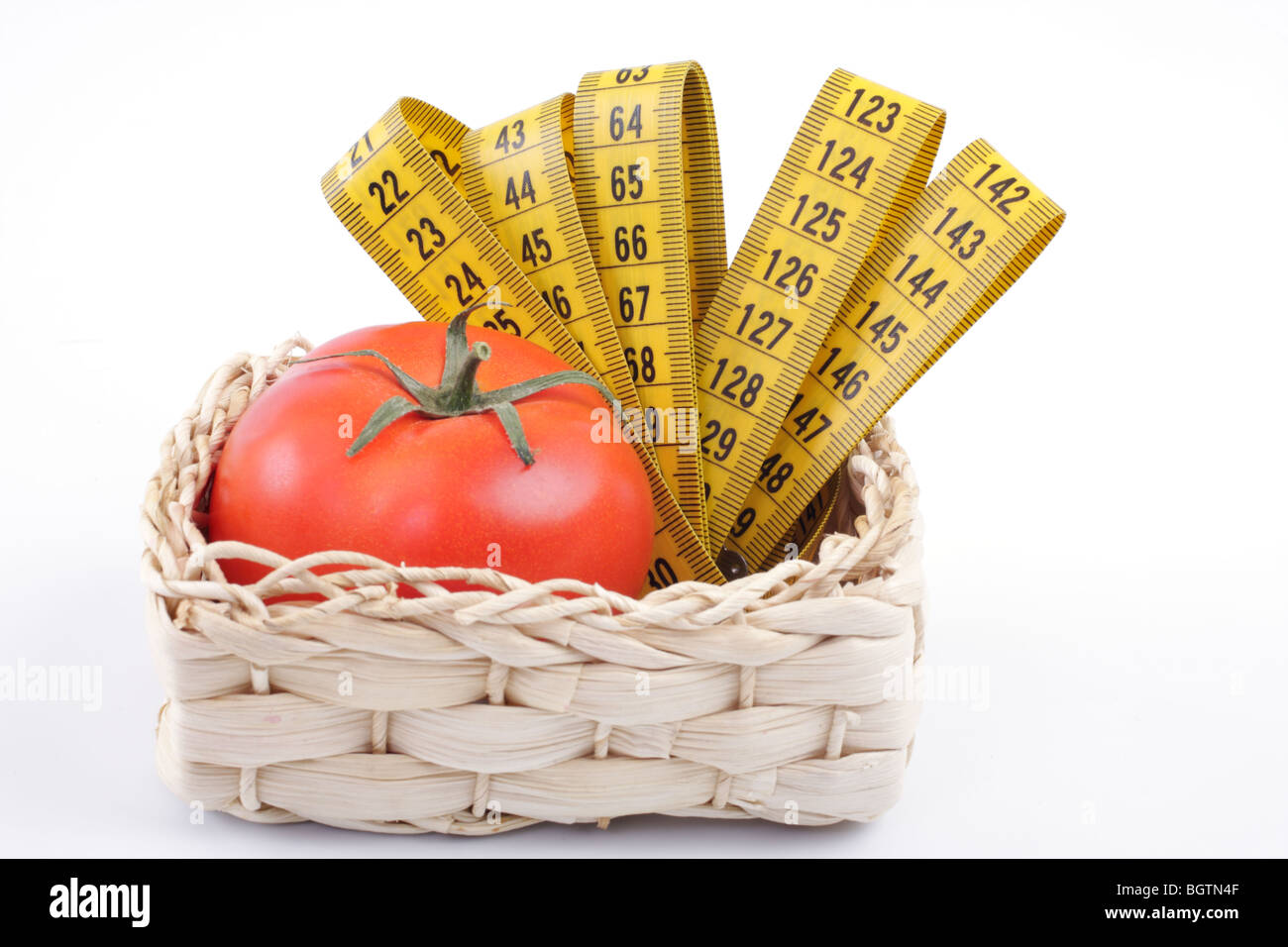 Tomates avec un ruban à mesurer, isolé studio Banque D'Images