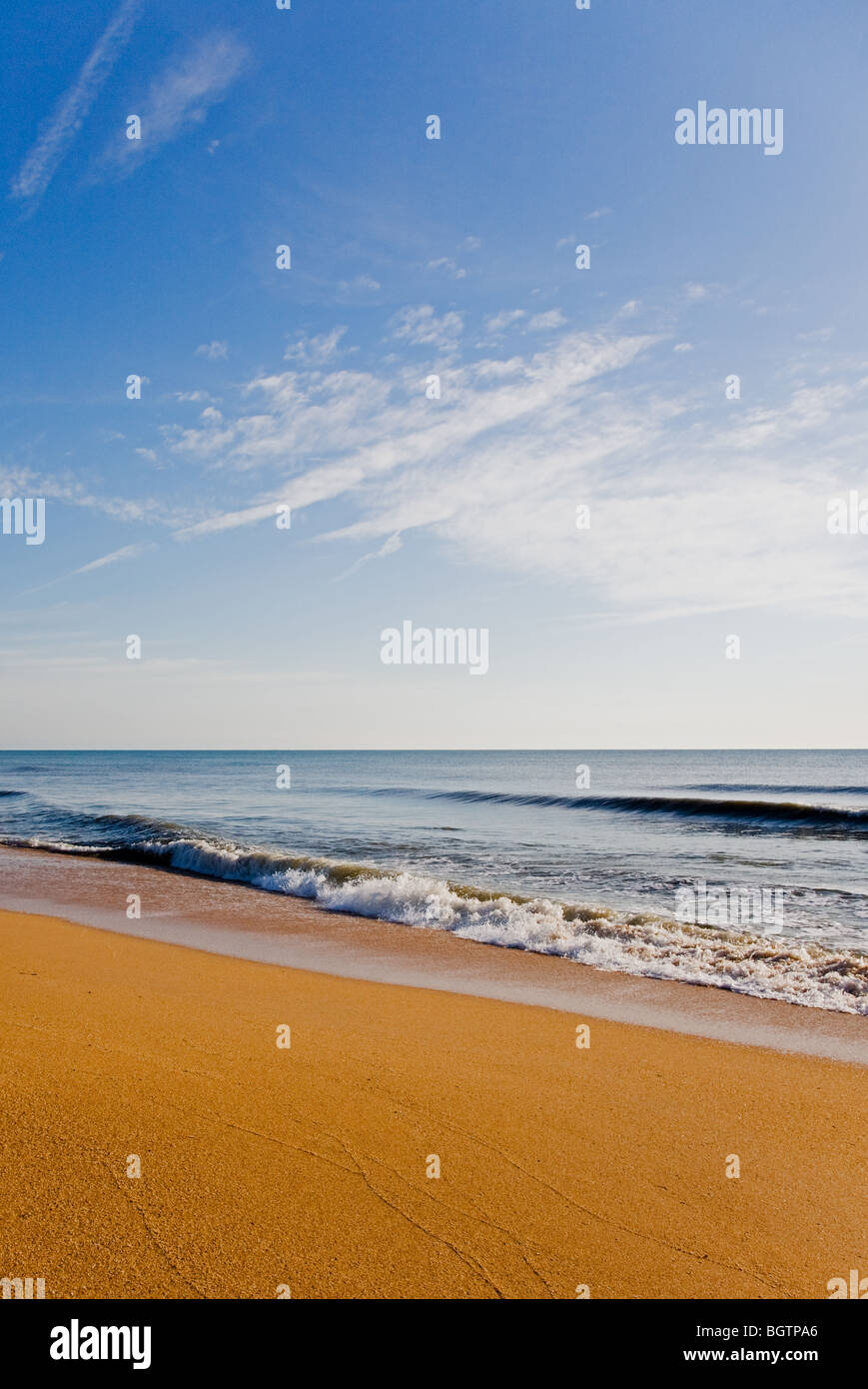 Tôt le matin, la lumière sur le sable de couleur riche et la plage de surf Banque D'Images