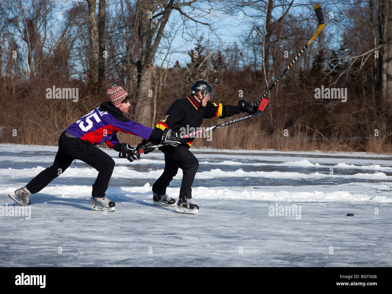 Jouer au hockey sur glace sur un étang gelé Banque D'Images