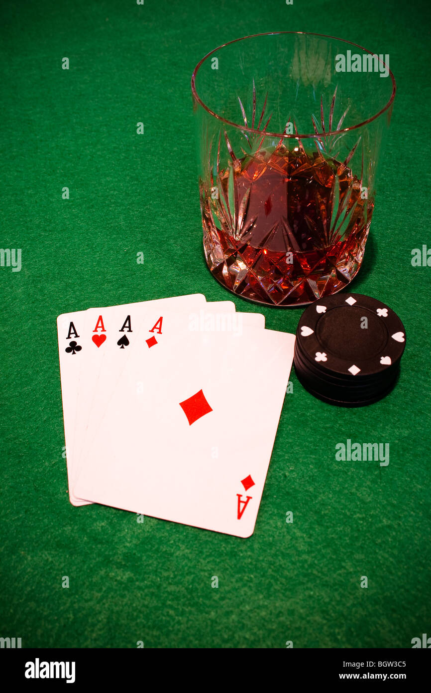 Quatre as, des jetons de poker et un gobelet de whisky Banque D'Images