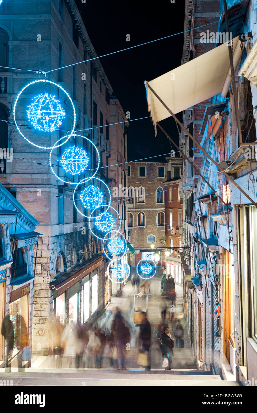 Les touristes marcher la nuit sur le pont du Rialto à la recherche à l'boutiques sous les décorations de Noël avec des lumières LED. Venice Banque D'Images