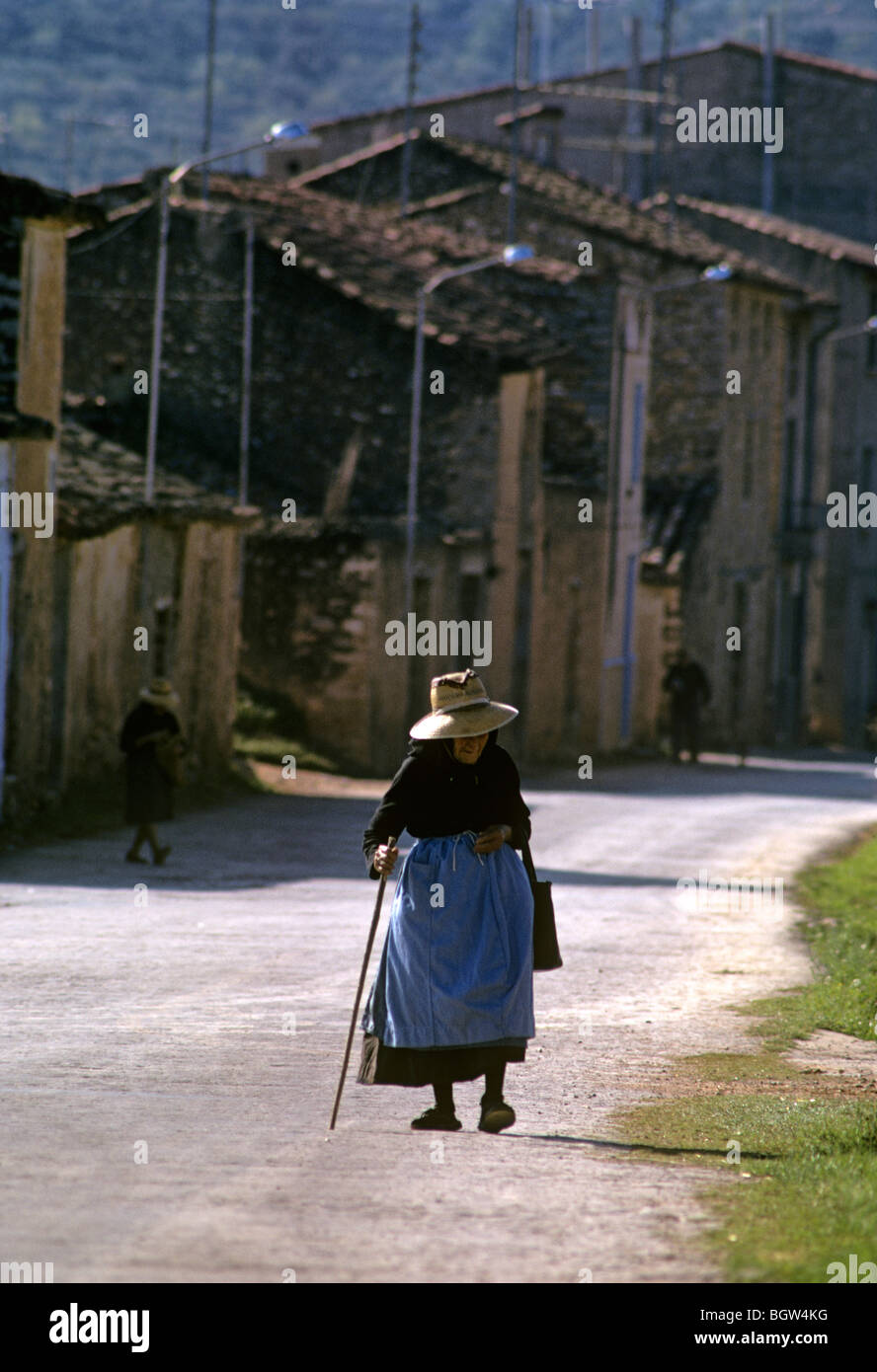 L'Espagne. Vieux village andalou woman walking passé un projet de construction. Banque D'Images