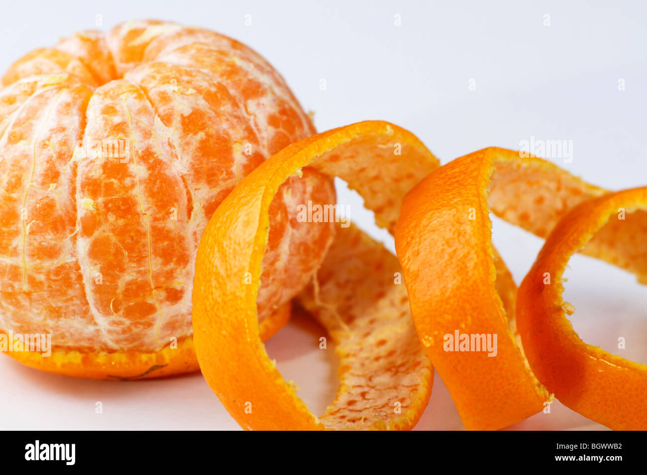 Une orange pelée sur fond blanc Banque D'Images