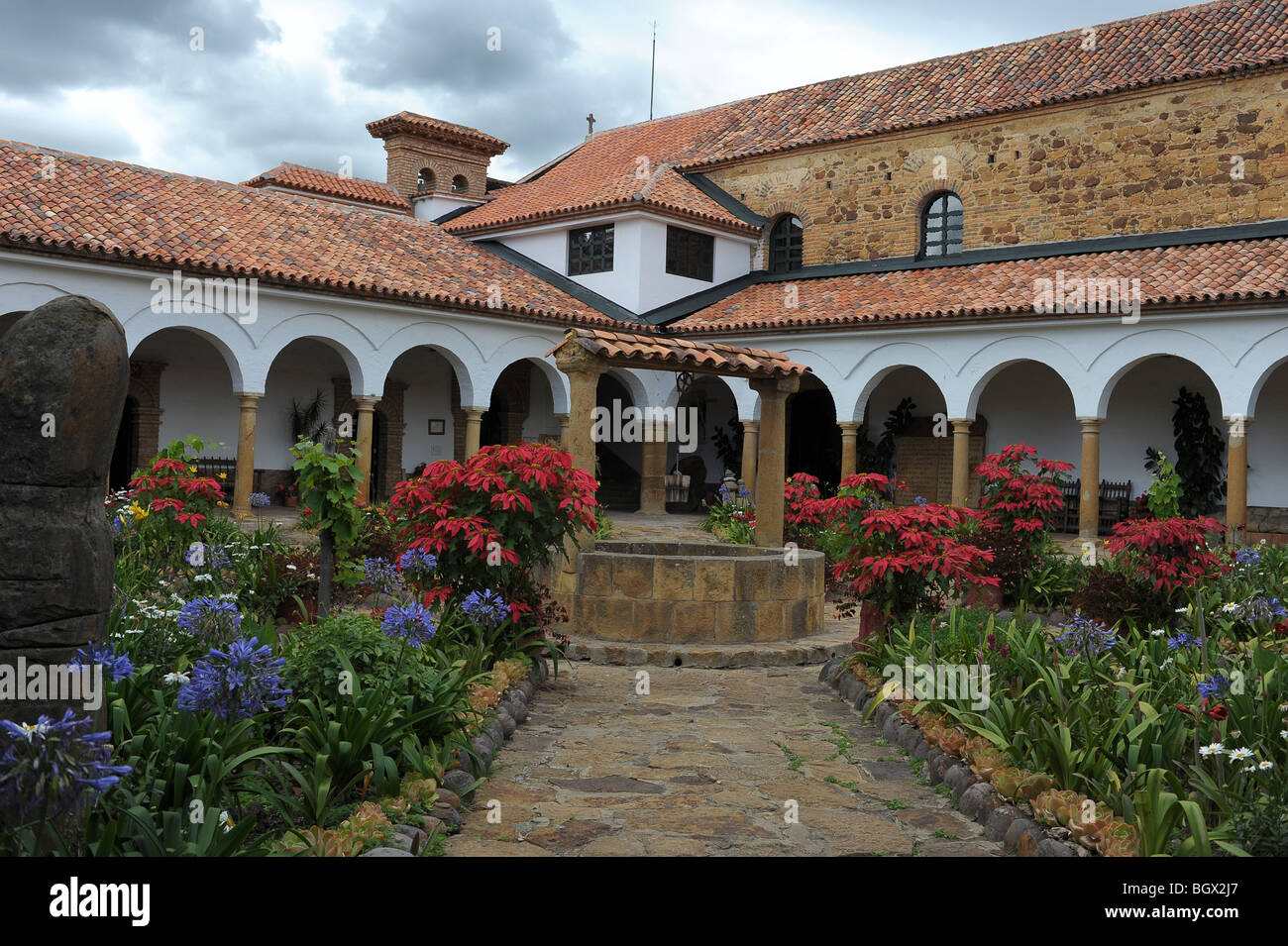 Convento de Santo Ecce Homo cour avec pierres taillée, des fleurs colorées et des chemins autour de puits central. Colombie Banque D'Images