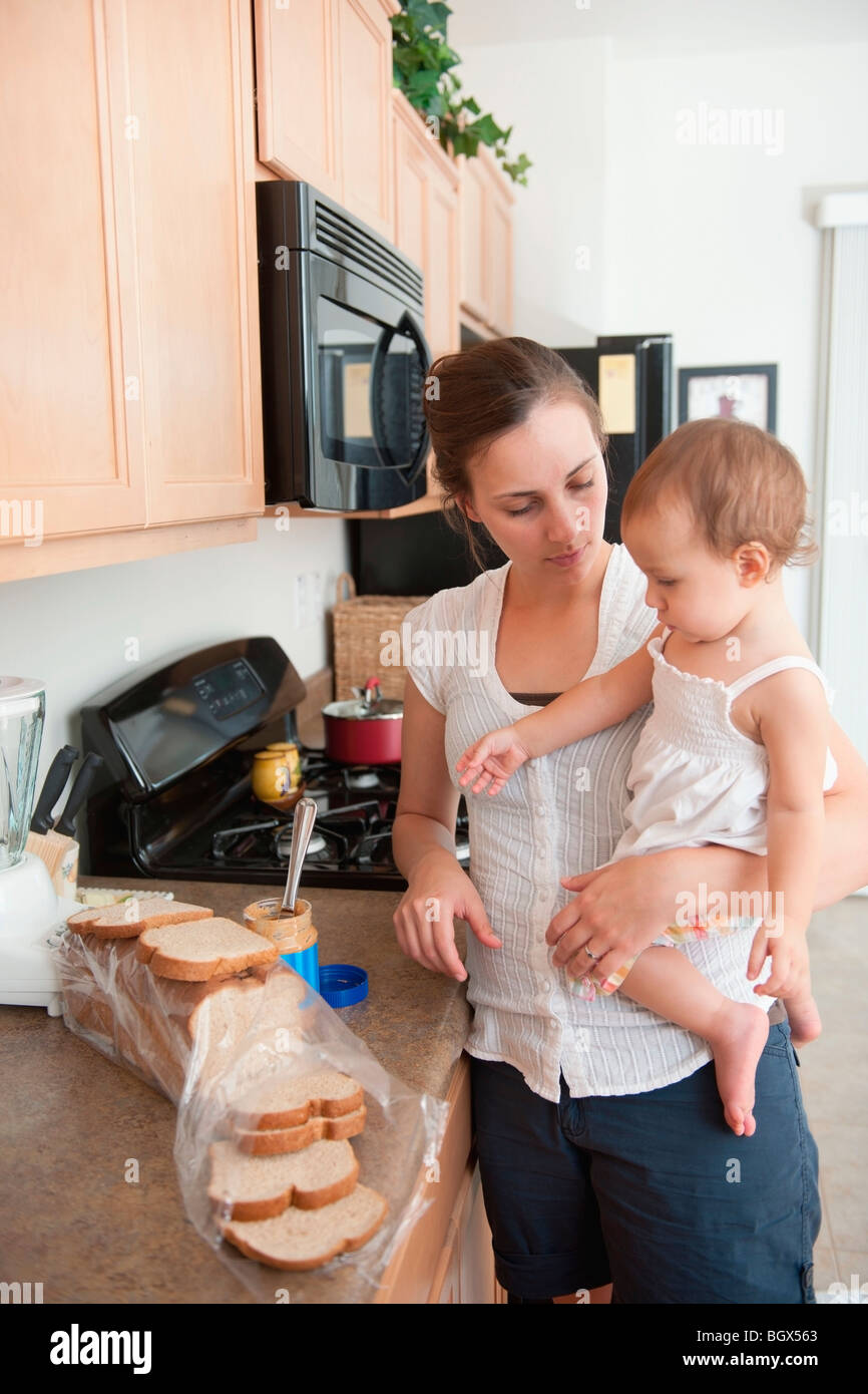 Une mère de faire un sandwich pour sa petite fille Banque D'Images