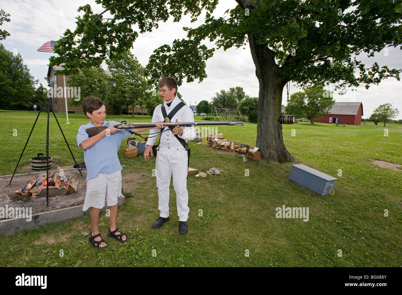 Teen boy holding Guerre de 1812 reenactor's mousquet. Banque D'Images
