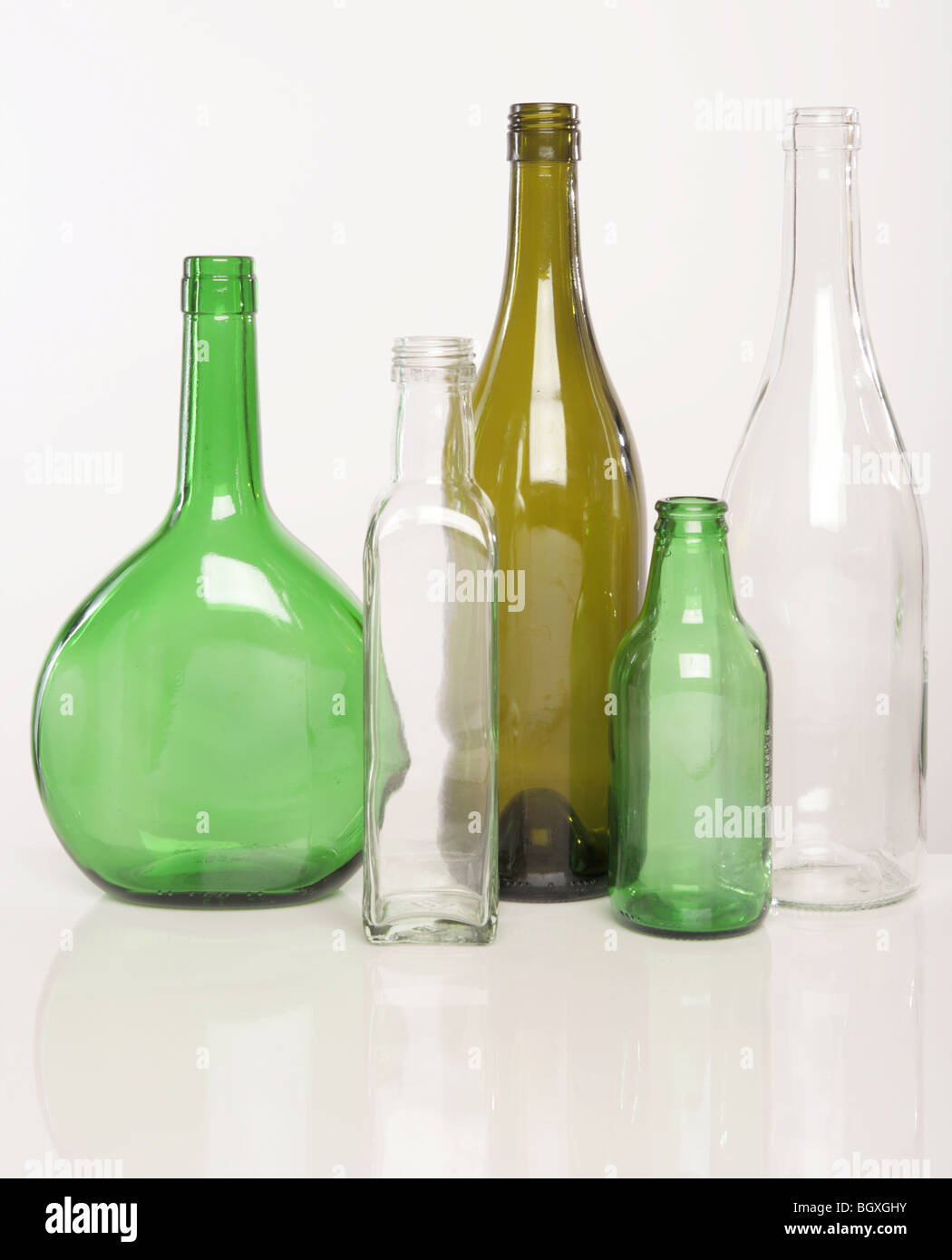 Vert Brun et verres et bouteilles en verre clair photographié sur un fond blanc. Banque D'Images