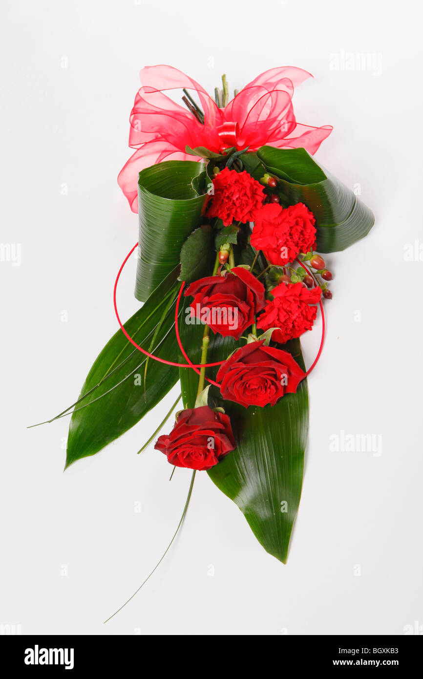 Un cadeau de Saint Valentin roses rouges et des œillets rouges dans un arc Banque D'Images