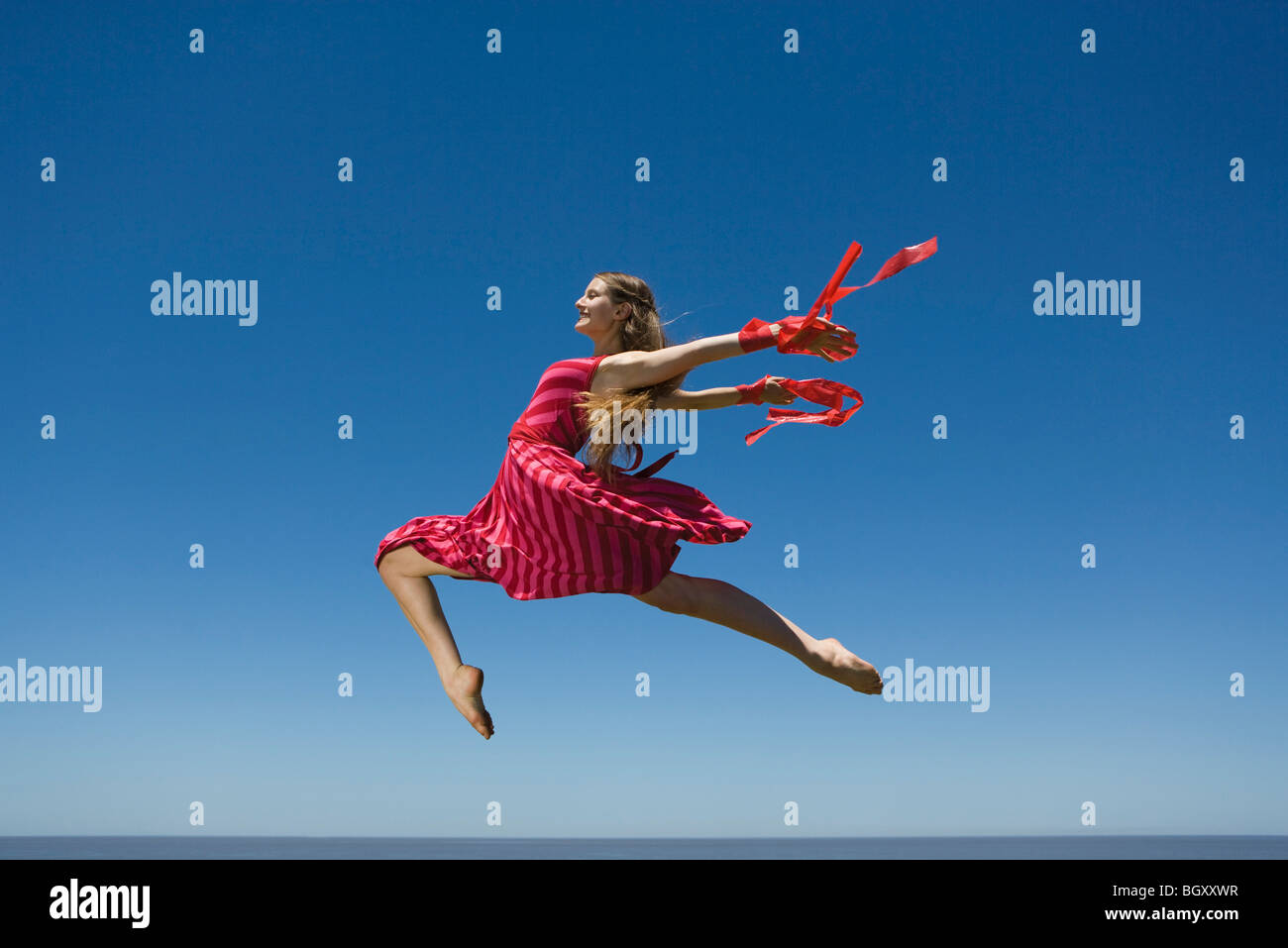 Jeune femme sautant, plein ciel Banque D'Images