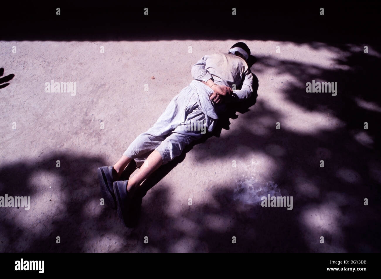 Les yeux bandés et un homme afghan lié à gauche sur le sol avant d'être interrogée dans une base de l'armée russe à Pyandzh, Tadjikistan Banque D'Images