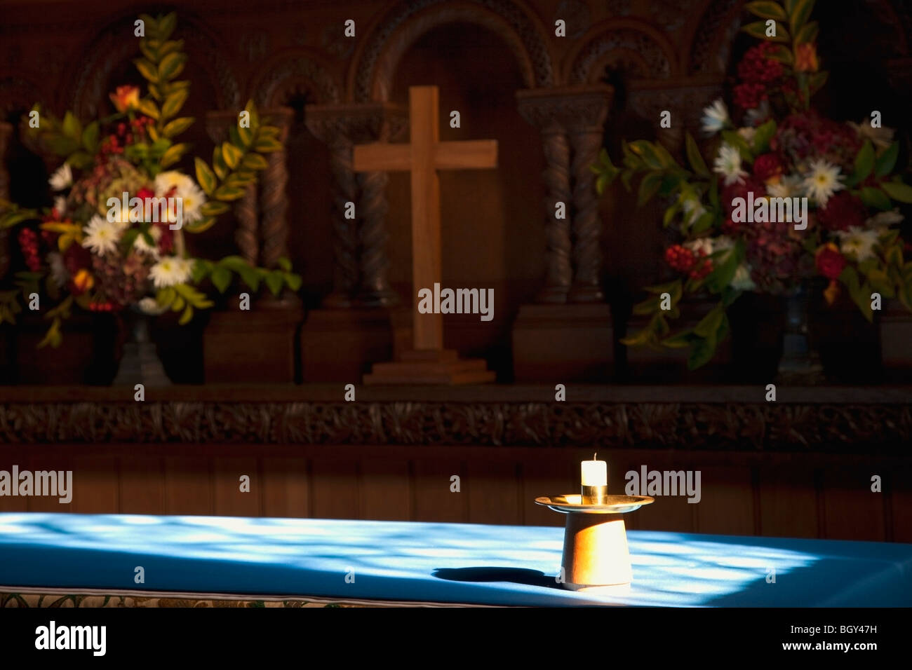 Bougie, croix et fleurs à l'autel Banque D'Images