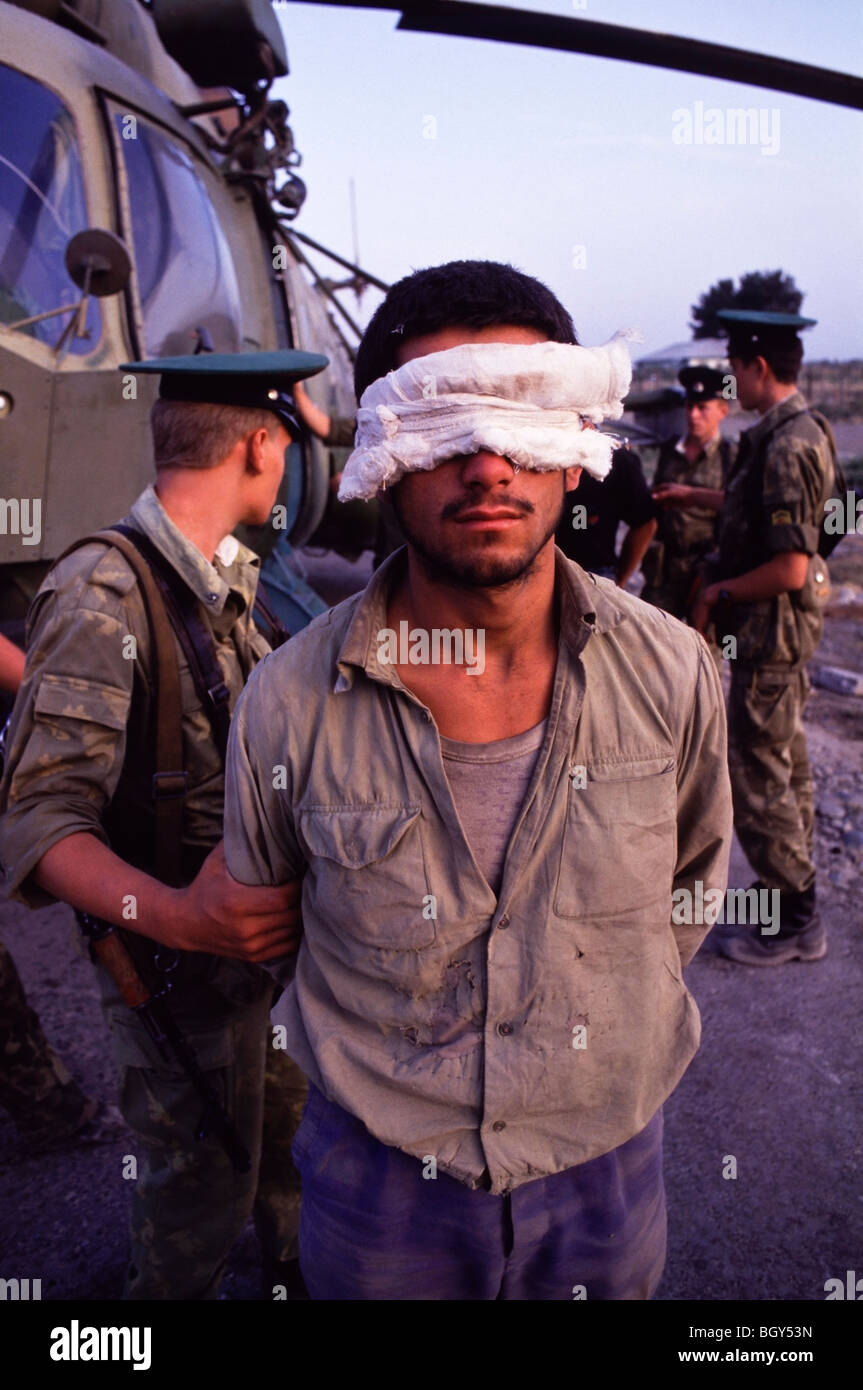 Des soldats russes un garde les yeux bandés arme tadjiks passeur à côté d'un hélicoptère Mi-8 russe à Pyandzh, Tadjikistan Banque D'Images