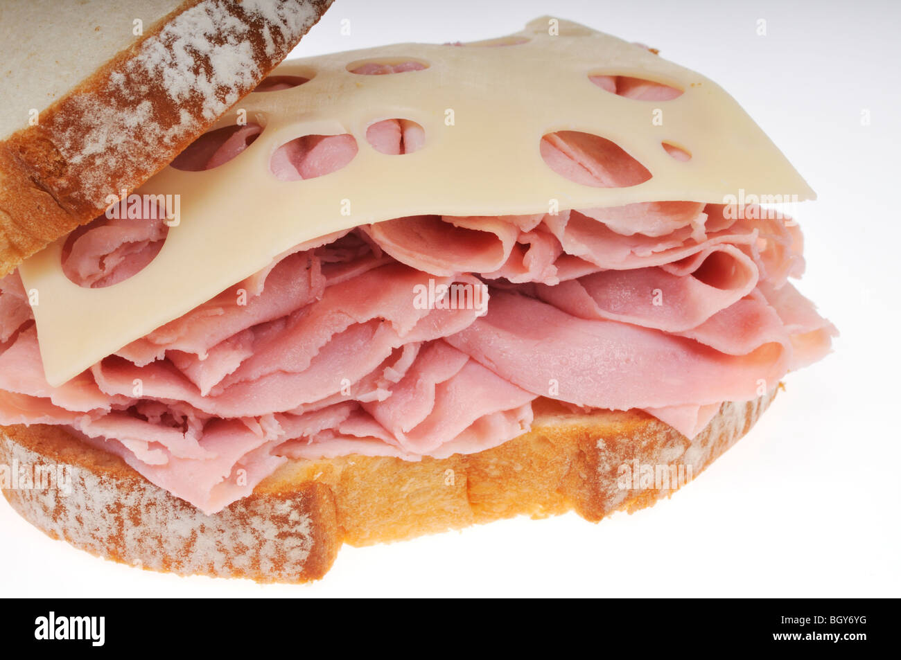 Avant de l'ouvrir le jambon et fromage suisse le sandwich sur pain blanc sur fond blanc Banque D'Images