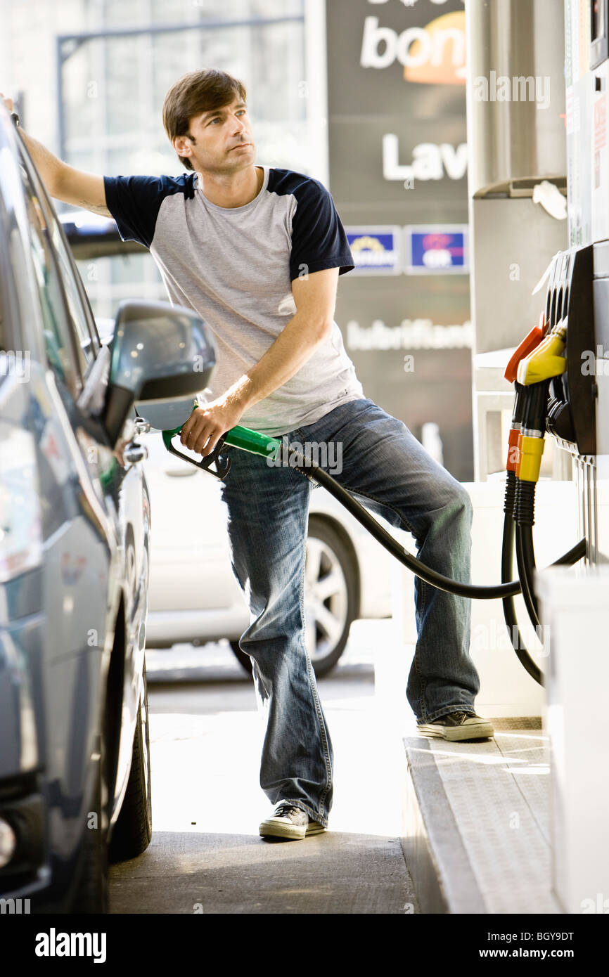 Véhicule de ravitaillement de l'homme à la station de gaz Banque D'Images