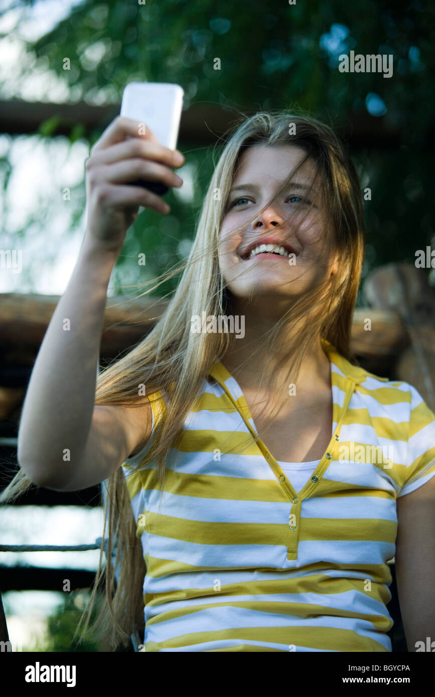 Jeune femme photograhing avec appareil photo numérique auto Banque D'Images