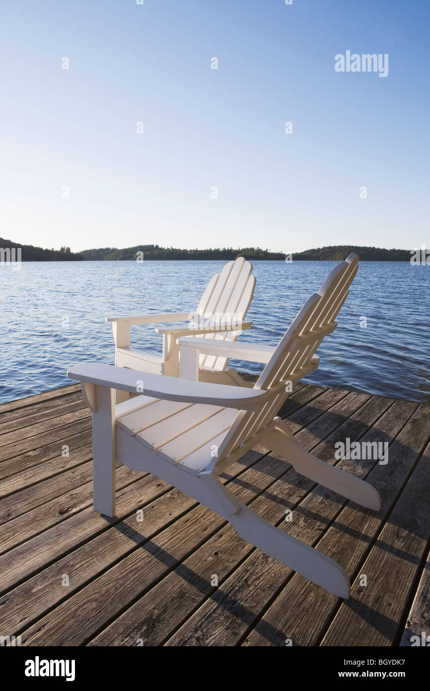 Chaises Adirondack on dock Banque D'Images