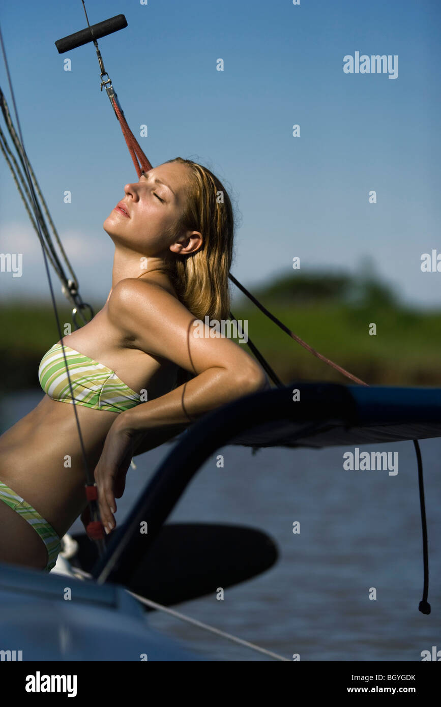 Woman sunbathing on boat Banque D'Images