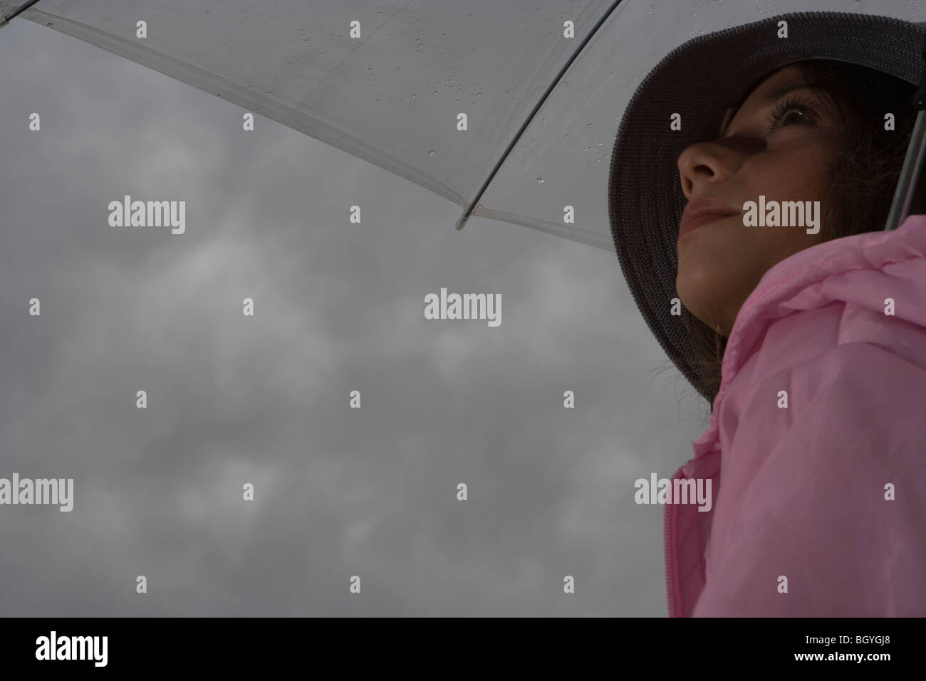 Femme avec parapluie looking up Banque D'Images