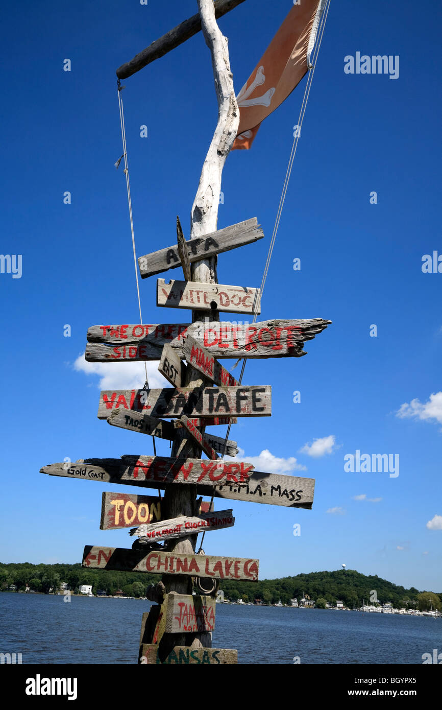 La direction et la distance sur l'ancien panneau en bois sur le quai à côté de S.S. Keewatin à vapeur sur le lac Michigan Kalamazoo USA Banque D'Images
