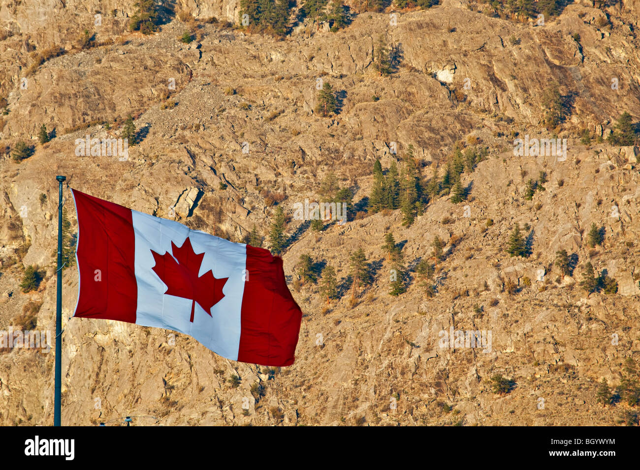 Backdropped drapeau canadien par le paysage aride de Osoyoos, région Okanagan-Similkameen, Okanagan, Colombie-Britannique, Canada. Banque D'Images
