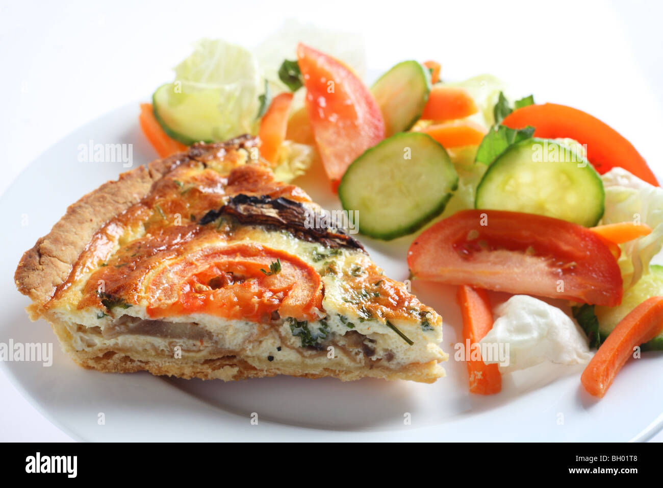 Un champignons, tomates et persil quiche servi avec une salade. Banque D'Images