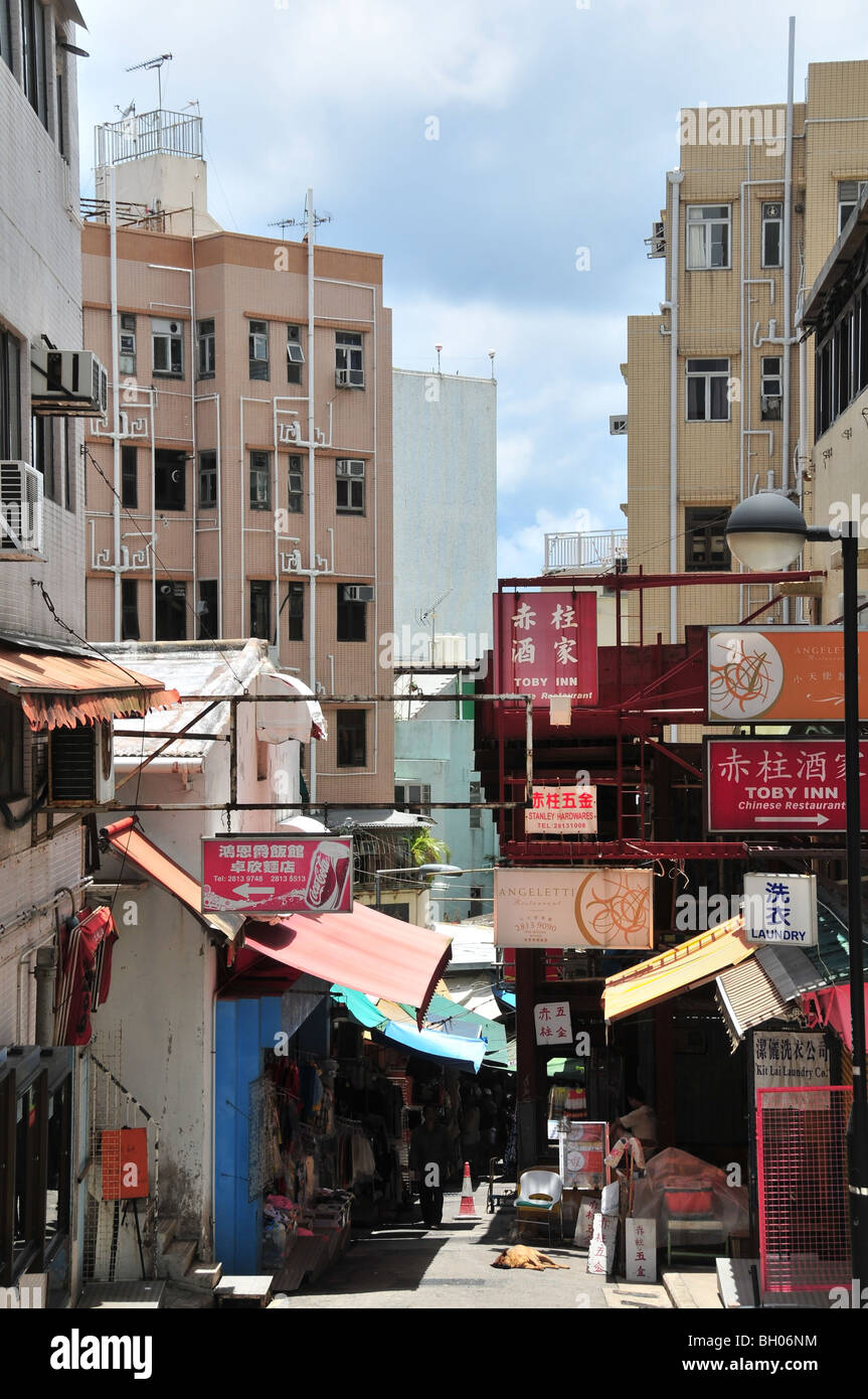 Boutiques en plein air, à l'ombre des stores, blocs d'appartements ci-dessous sur les côtés d'une rue de Stanley Market, Stanley, Hong Kong, Chine Banque D'Images