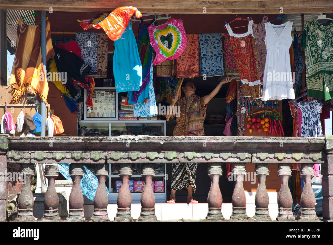 Un propriétaire de magasin balinais afficher ses marchandises, Bali, Indonésie. Banque D'Images