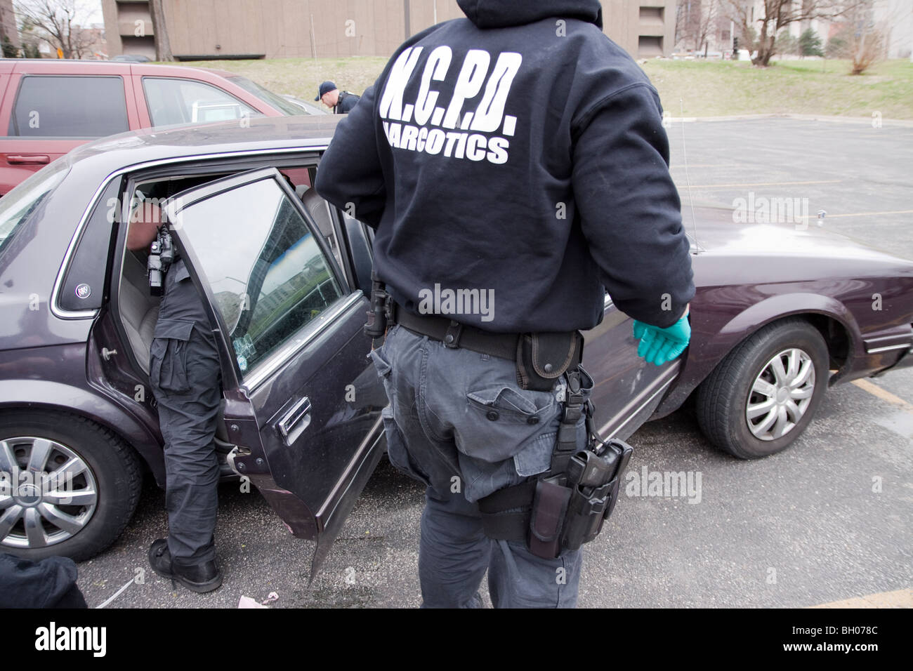 Les fonctionnaires de police soupçonnés de véhicule recherche revendeur de drogue après avoir arrêté le conducteur. Banque D'Images