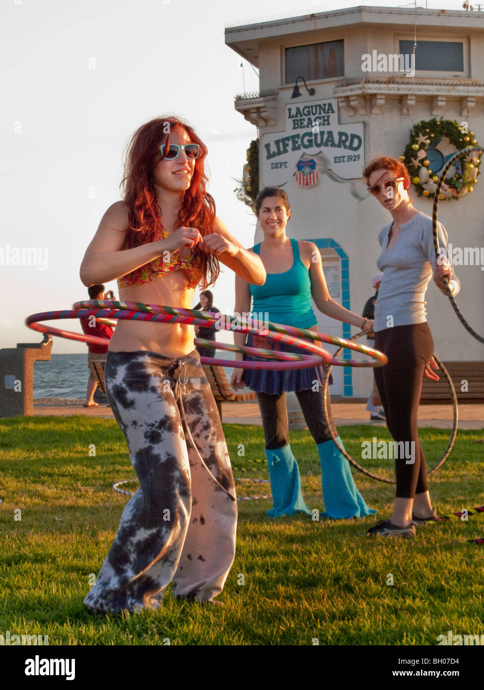 Heureux les amateurs de hula hoop tenir une session' 'Hoopnosis en fin d'après-midi à Laguna Beach, CA. Remarque lifeguard building Banque D'Images