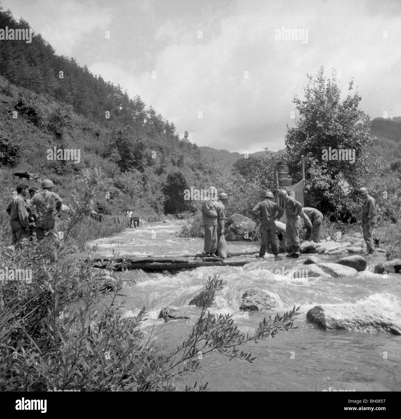 Au cours d'une pause à partir de la guerre de Corée, la lutte contre les membres de l'armée américaine, deuxième division d'infanterie faire la lessive dans une rivière. Banque D'Images