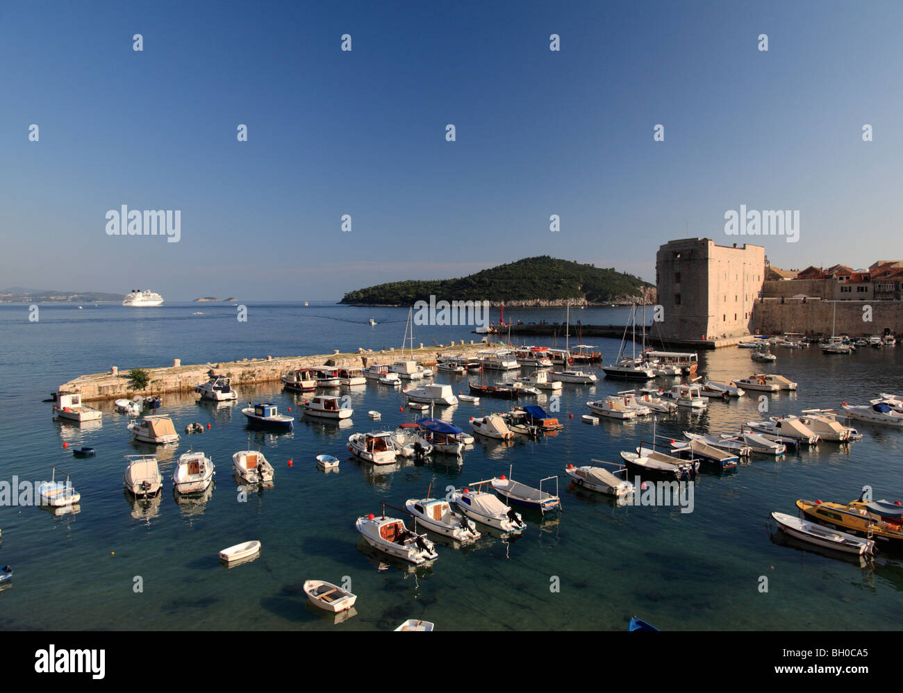 Le Port de Dubrovnik avec de petits bateaux de pêche et grand bateau de croisière amarré dans la baie Croatie Banque D'Images