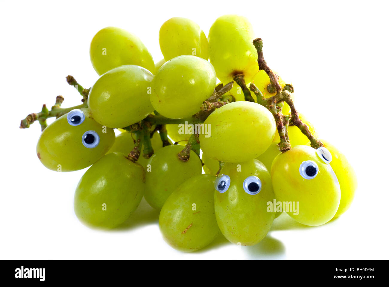 Découper une image d'une grappe de raisins avec cartoon yeux attachés à certains des raisins Banque D'Images