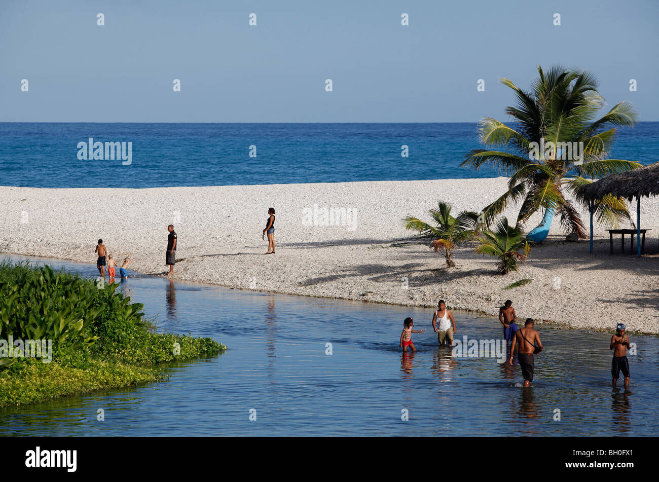 Personnes nageant dans une rivière d'eau douce qui se jette dans la mer des Caraïbes, Playa San Rafael, République Dominicaine Banque D'Images