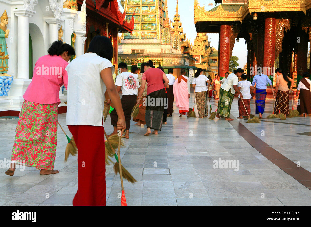 Faire du bien aux femmes de Buddhistic leur karma balayent la pagode Shwedagon, Rangoon, Myanmar, Birmanie, Asie Banque D'Images