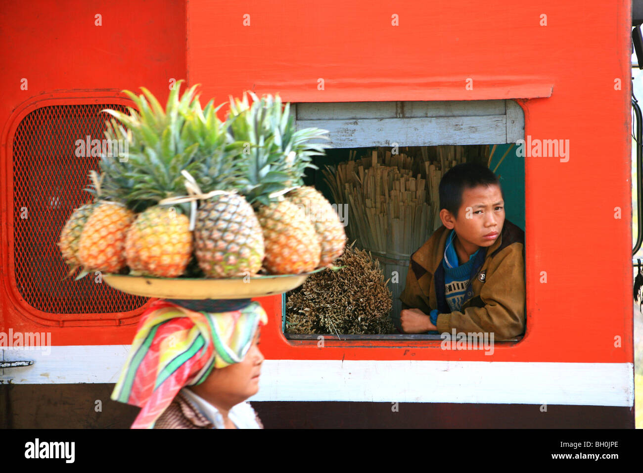 Une femme vend des fruits, un garçon à la recherche par la fenêtre d'un train, Hispaw, Shan State, Myanmar, Birmanie, Asie Banque D'Images