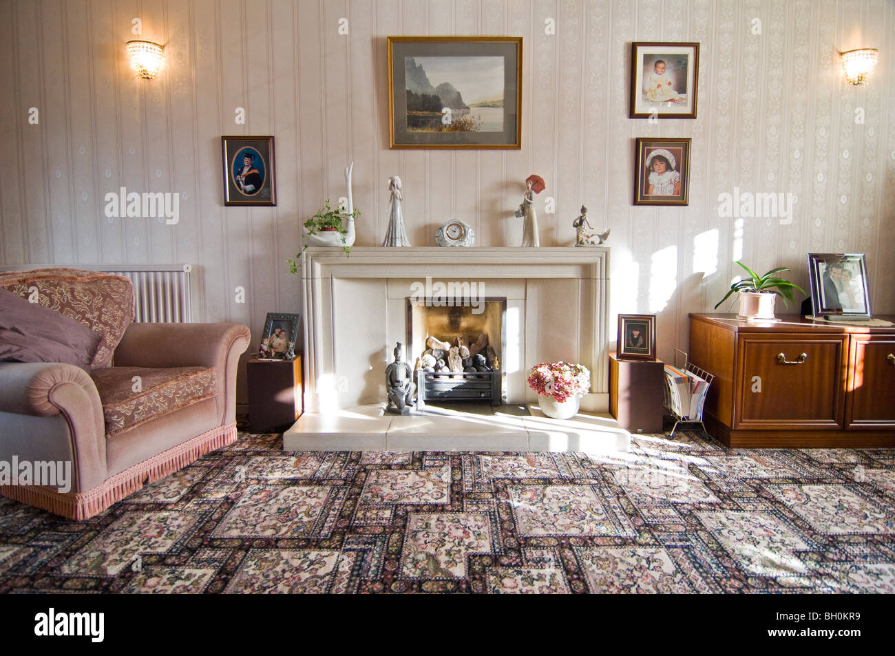 Grand angle horizontal intérieur d'un vieux jeu traditionnel salon avec tapis à motifs et grande cheminée en pierre. Banque D'Images