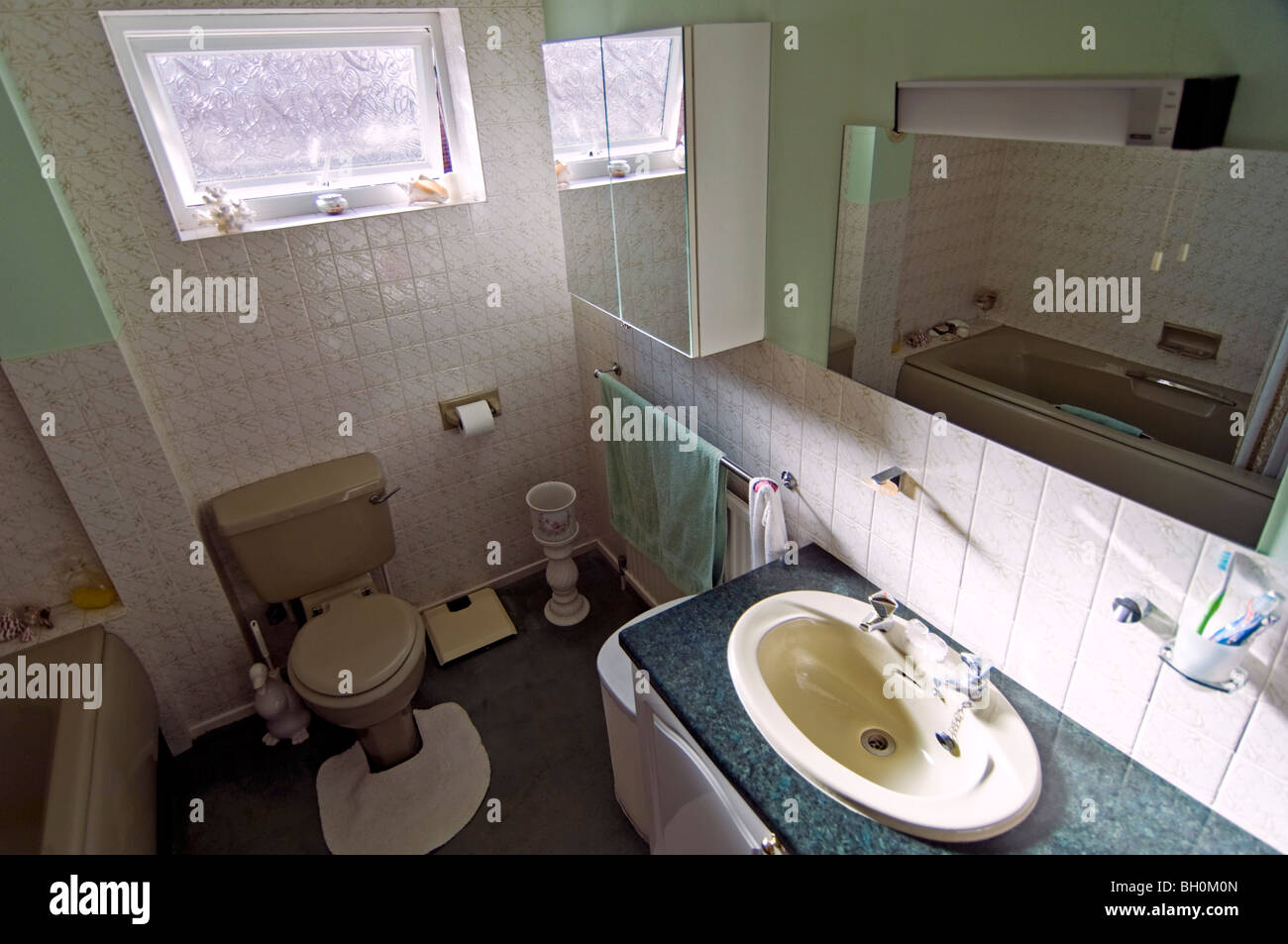 Grand angle horizontal de l'intérieur un vieux 80's salle de bains avec un bain de couleur verte. Banque D'Images