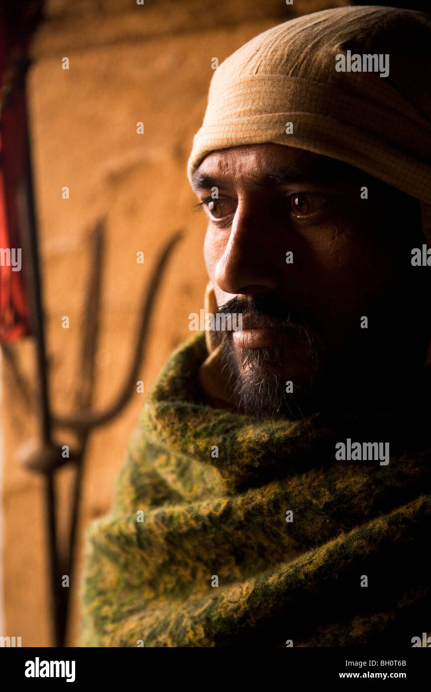 Un Dom, l'une des castes hindoues impliqués dans cremating les morts, est à la source de la flamme éternelle à Varanasi, Inde. Banque D'Images