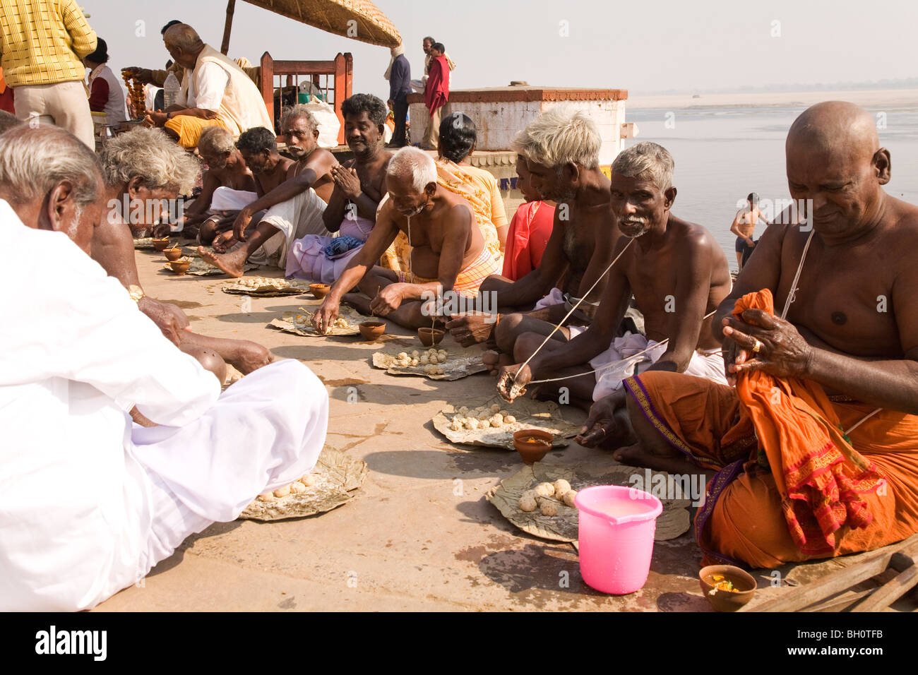 Les membres d'une famille hindoue indienne s'asseoir ensemble sur les ghats de Varanasi, Inde, impliqué dans une cérémonie de deuil rituel. Banque D'Images