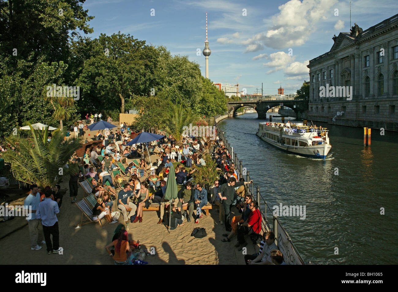 Les gens se détendre au bord de la rivière Spree dans la lumière du soleil, l'île aux musées, Berlin, Germany, Europe Banque D'Images