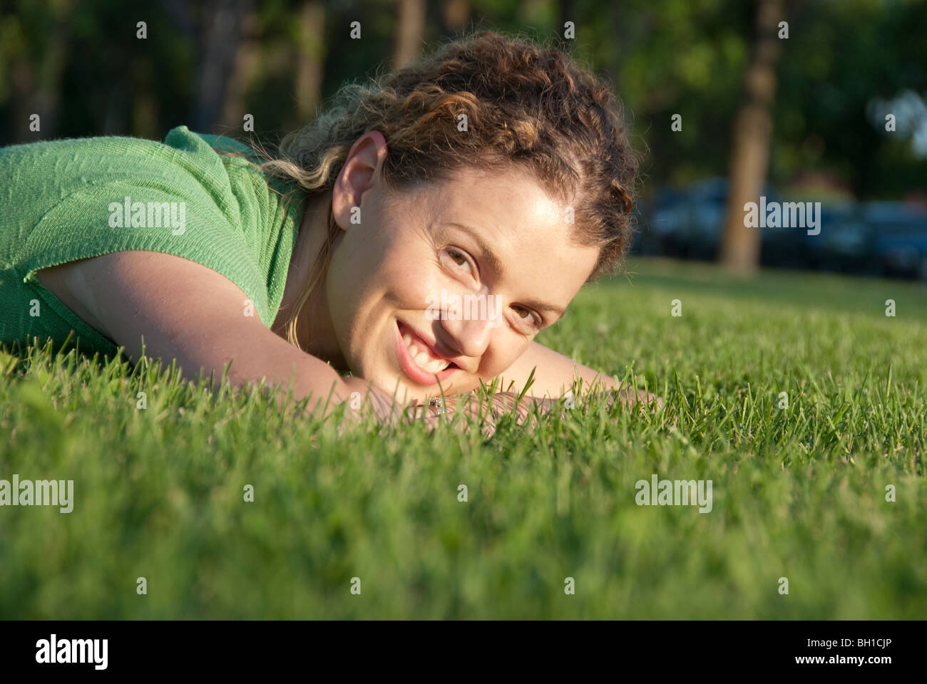 Femme souriante sur l'herbe, Parc Assiniboine, Winnipeg, Manitoba, Canada Banque D'Images