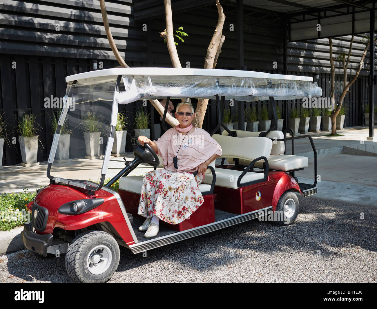 Thaïlande danse et théâtre doyen Pataradi Mejudhon utilisant une voiture électrique pour transporter des visiteurs autour de son lieu, Hua Hin Thaïlande Asie Banque D'Images