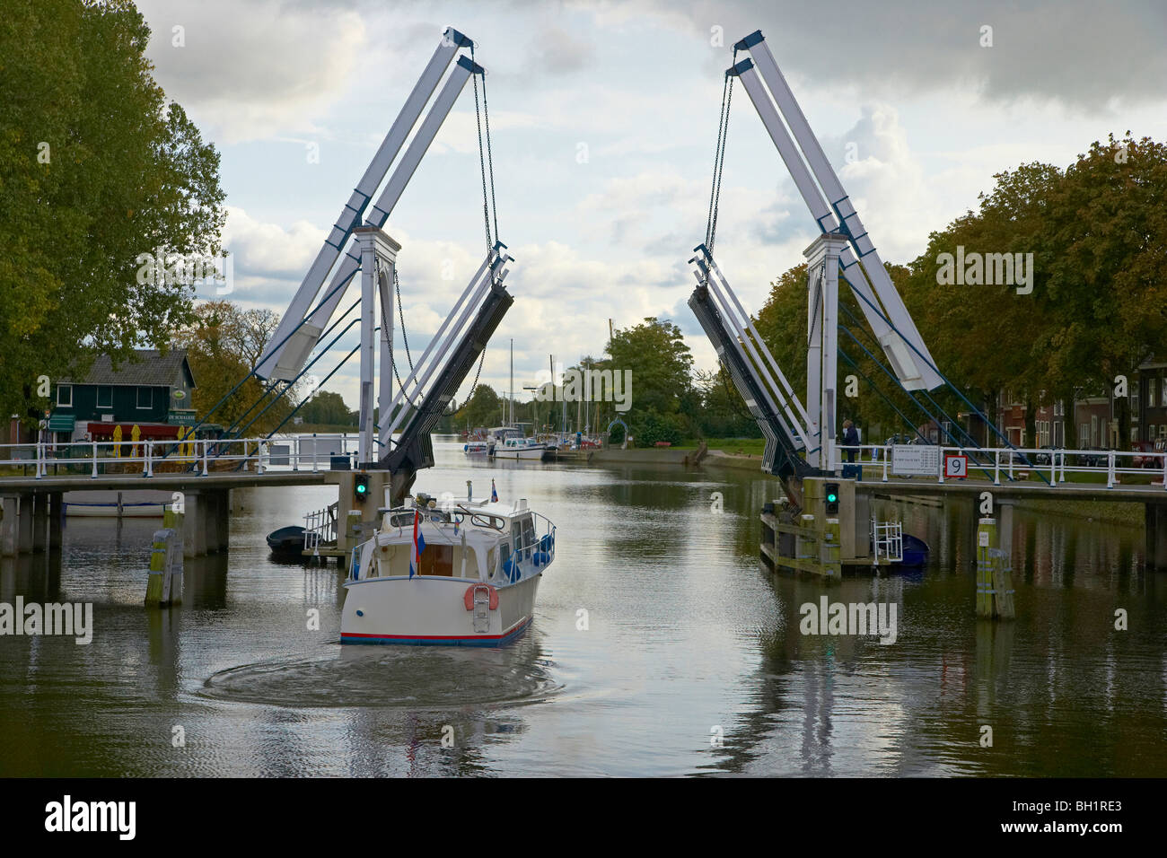 Un bateau à moteur sur la rivière Vecht conduisant au-delà d'un pont à bascule, Pays-Bas, Europe Banque D'Images