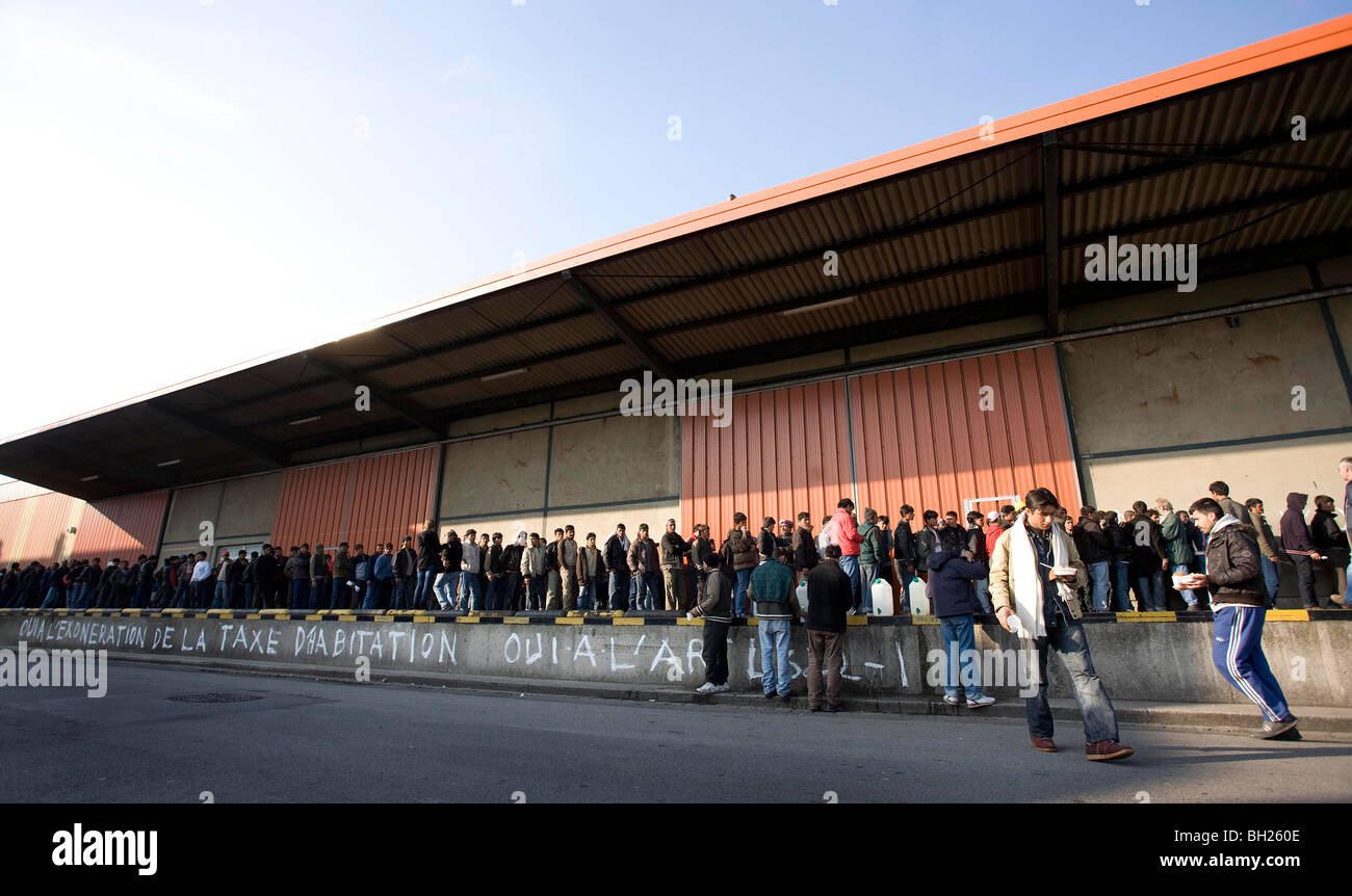 Les migrants à attendre en ligne à un ravito à Calais, dans le Nord de la France. Photographie de James Boardman Banque D'Images